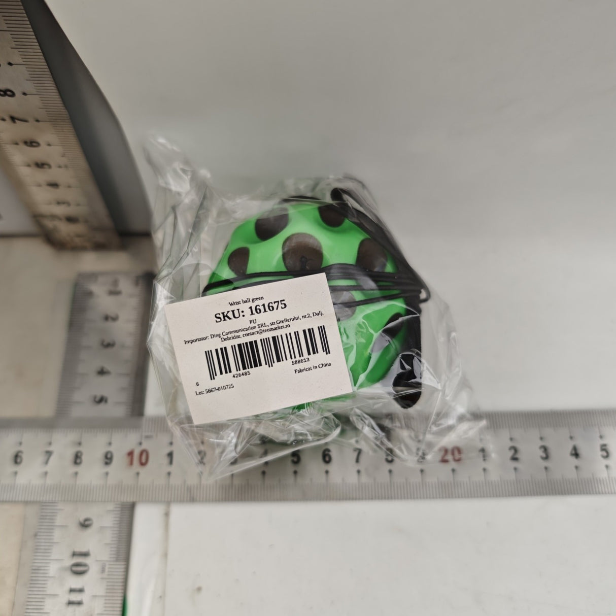 Minge antistres Space Moon Ball verde ținută în mână, demonstrând dimensiunea compactă de 66 mm