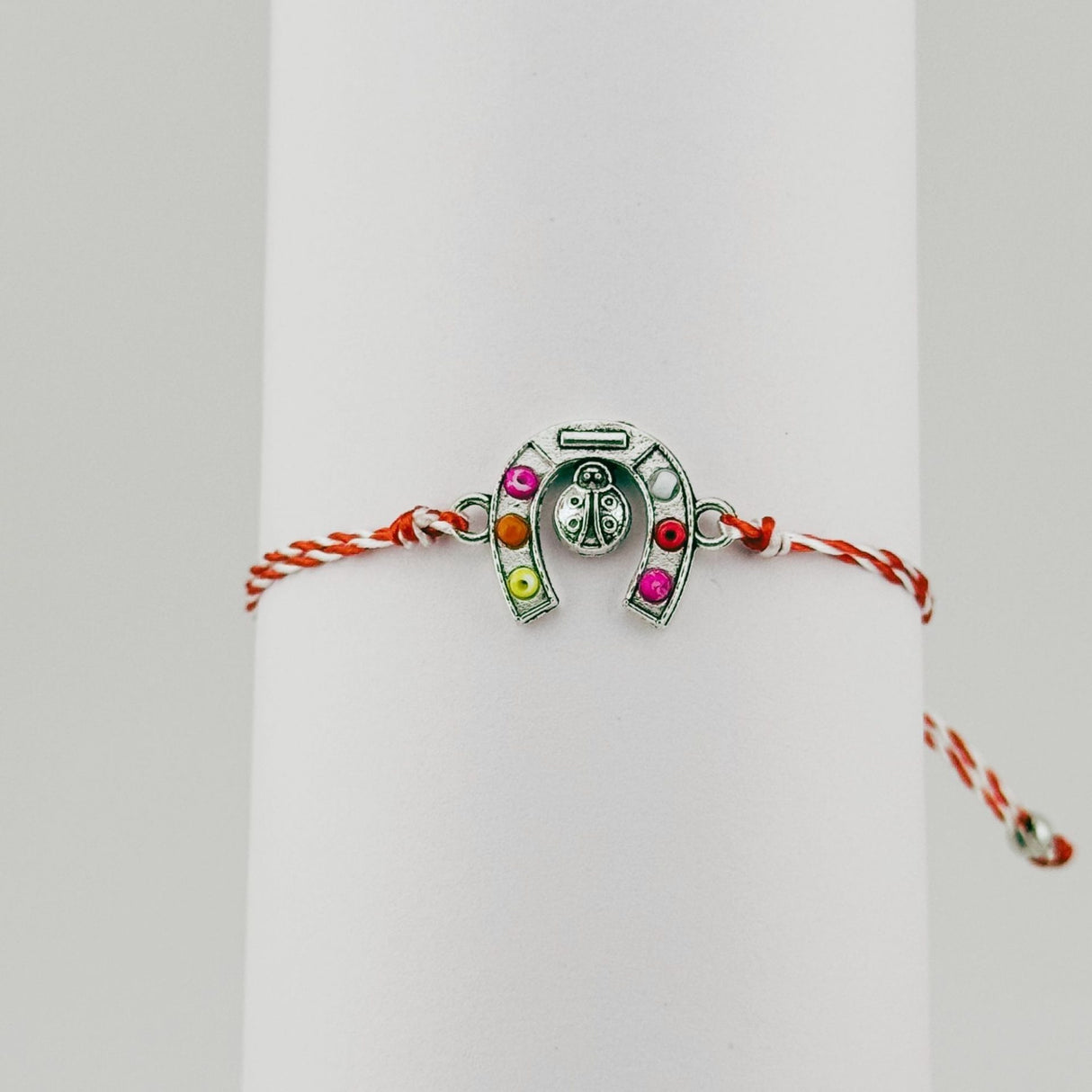 Brățară mărțișor Jolie purtată pe încheietură, model potcoavă argintie cu șnur alb-roșu, stil elegant