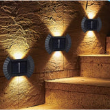 Set 4 Aplice solare LED Bidirectionale pentru perete Flippy, in forma de funda, 8 LED-uri, material ABS si PC, lumina puternica, IP65, 10 x 7.5 cm, baterie 1.2 V, 300 mAh, autonomie 8-10 ore, alb cald