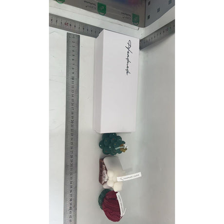 Detaliu figurine lumânări parfumate din ceară de soia: bradut verde cu steluță aurie și mănușă tricotată roșie-verde