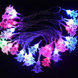 Detaliu ornament brăduț din plastic al ghirlandei luminoase multicolore pe fir transparent