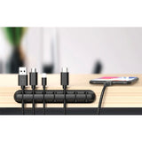 Organizator cabluri autoadeziv negru cu cabluri USB și încărcătoare introduse în suporturi